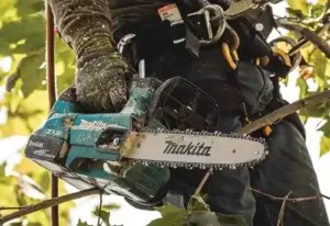 A man holding a Makita DUC306 Chainsaw. Battery operated chainsaw. Best chainsaw Review